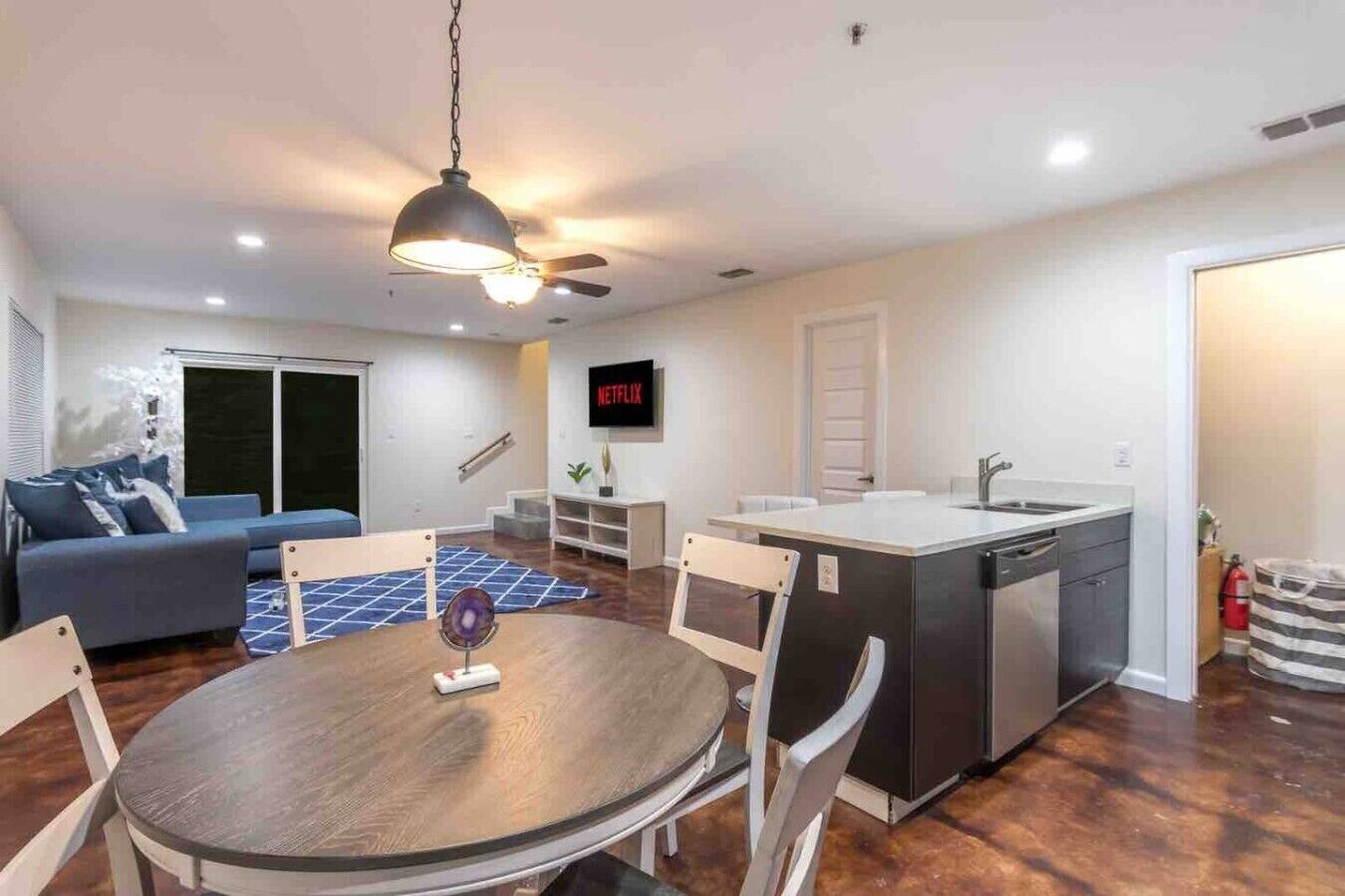 A modern apartment with a dining area, kitchen, and living room.
