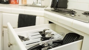 A kitchen with a drawer containing utensils, a microwave, and a coffee maker. - Central Junior Suite Fast-WiFi  First Floor (McAllen)
