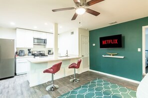Eine moderne Küche mit Mikrowelle, Kaffeemaschine und Deckenventilator.