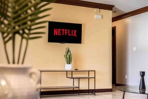 A wall-mounted television with the word 'NETFLIX' displayed in red letters.