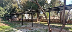A covered outdoor area with a stone wall and trees.