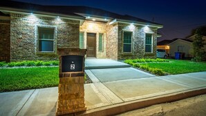 Um prédio residencial com fachada de pedra, uma caixa de correio com o número 2 e uma entrada com acesso por meio de uma rampa.