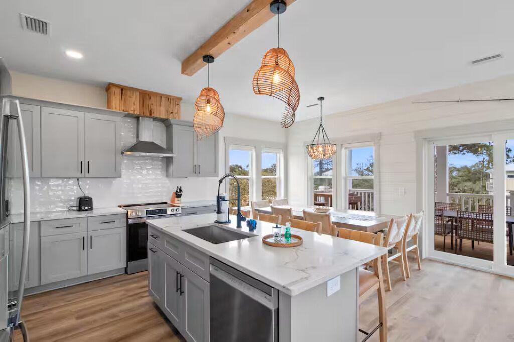 A modern kitchen with a large island, stainless steel appliances, and pendant lighting.. Pool, Putting Green, Boat Parking, Giant Sand Pit, Steps to Beach