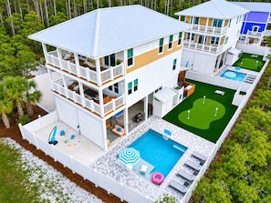 A multi-story house with a pool, outdoor seating, and a golf course. - Pool, Putting Green, Boat Parking, Giant Sand Pit, Steps to Beach (Port St. Joe)