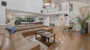 Ein großzügiger Wohnbereich mit einer großen Couch, einem Couchtisch und einer Treppe zu einer oberen Ebene.