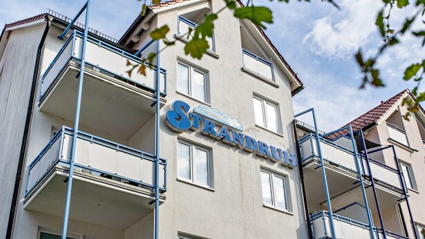 A multi-story building with balconies and a sign that reads 'Strandru.' - Apartment 'Ringstr. 20, 2. OG Rechts WE66' with Balcony and Wi-Fi (Binz)