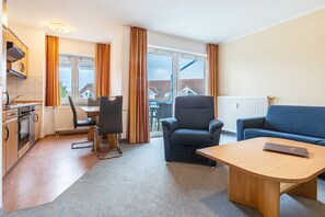 Une chambre d’hôtel moderne dotée d’une cuisine, d’un coin repas et d’un canapé.
