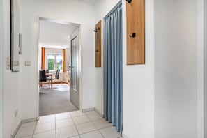 En hall med ett matområde, en dörr och en gardin.