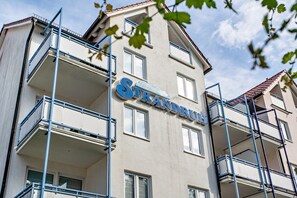 Ein mehrstöckiges Gebäude mit Balkonen und einem Schild mit der Aufschrift 'Strandru'.