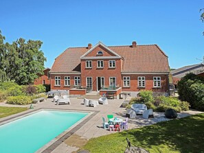 A large brick house with a swimming pool, outdoor seating, and a well-maintained garden. - 4 Star Holiday Home in Lundby (Lundby)