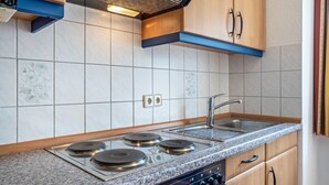 A kitchen with a Siemens stove, a sink, and wooden cabinets. - Apartment 'Ringstr. 22, 1. OG Rechts WE44' with Balcony and Wi-Fi (Binz)