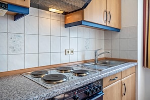 A kitchen with a Siemens stove, a sink, and wooden cabinets. - Apartment 'Ringstr. 22, 1. OG Rechts WE44' with Balcony and Wi-Fi (Binz)