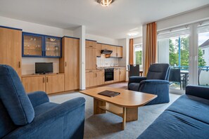 Ein modernes Wohnzimmer mit einer Couch, einem Couchtisch und einem Fernseher.