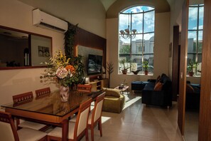 A spacious living area with a dining table, chairs, a sofa, and a TV. - Casa Mía : Private pool : 3 Bedrooms (cancun)