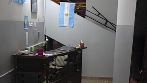 A narrow hallway with a kitchenette area, a potted plant, and a large water dispenser. - Punto 11 (Buenos Aires)