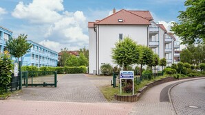 A residential building with a red-tiled roof, a gated entrance, and a paved driveway. - Apartment 'Mais. Ringstr. 22, 3.OG Rechts WE48' with Balcony and Wi-Fi (Binz)