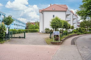Ein Wohngebäude mit rotem Ziegeldach, einem verschlossenen Eingang und einem gepflasterten Auffahrt.