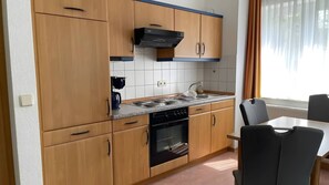 Une cuisine de taille réduite, avec des meubles de rangement en bois, une cuisinière et un évier.