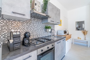 Una cocina moderna con estufa a gas, microondas y cafetera.
