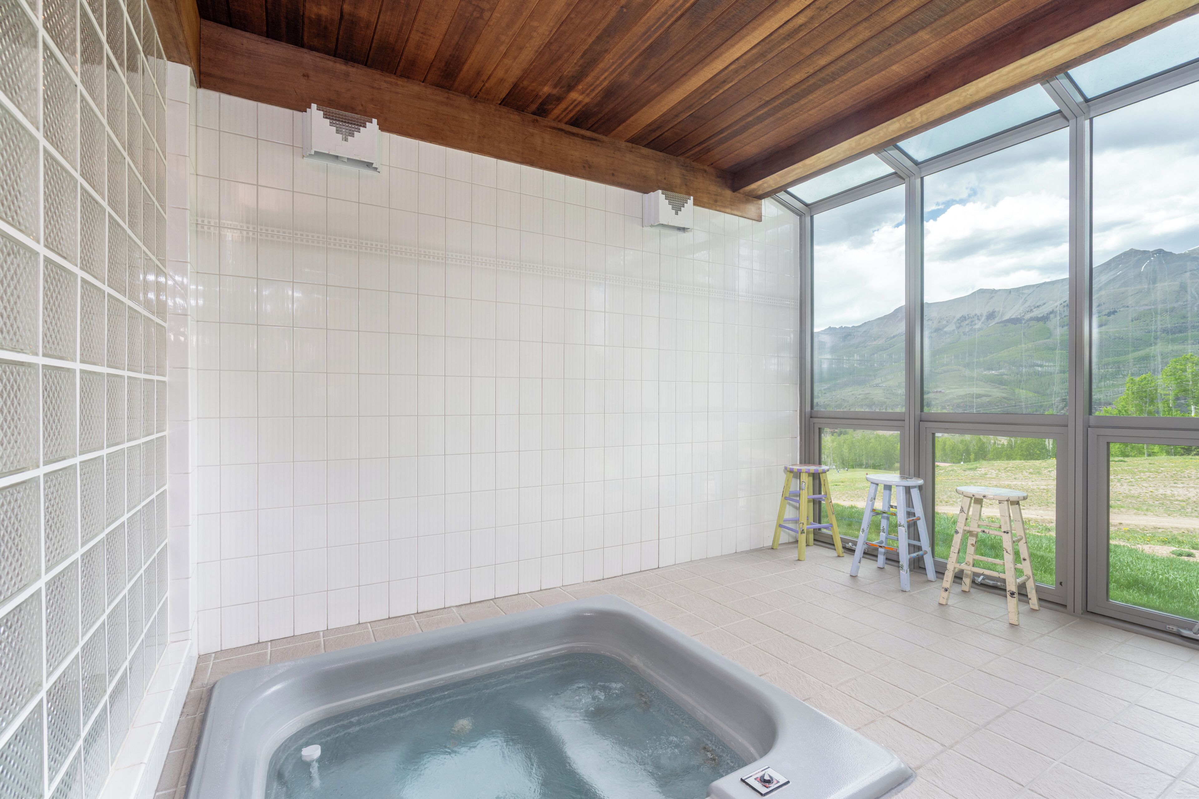 Un baño con bañera, ventanas amplias y vistas al exterior.
