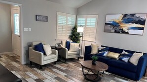 A living room with a herringbone floor pattern, two sofas, a coffee table, and a painting on the wall. - Vine Cottage- A Spacious, charming home-Walk to the square and SWU! (Georgetown)