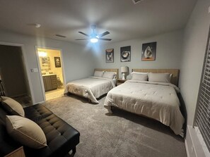 A bedroom with two beds, a ceiling fan, and a nightstand. - Vine Cottage- A Spacious, charming home-Walk to the square and SWU! (Georgetown)
