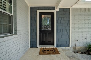A house with a black front door, a window, and a doormat with 'HOME' on it. - Vine Cottage- A Spacious, charming home-Walk to the square and SWU! (Georgetown)
