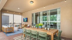 A dining area with a wooden table, green chairs, and potted plants. - NEW! Princess Theme! Minutes to Disney World! Private Pool and Hot tub! Theatre! (Kissimmee)