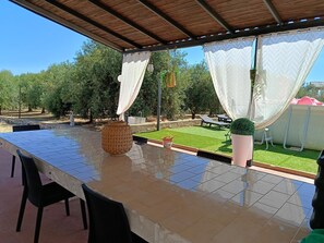 Un patio esterno con pavimento piastrellato, un cesto di vimini e una statua.