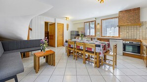Een moderne keuken met een eethoek, een bank en een houten tafel met stoelen.