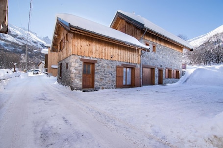 A wooden building with stone walls, snow-covered roof, and a clear sky.. Chalet Pascal 9 Valloire