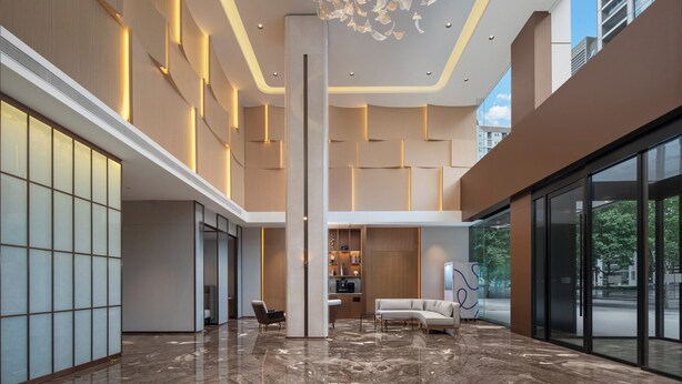 A spacious lobby with a high ceiling, a central column, and a seating area. - Holiday Inn Express Beijing Haidian Suzhouqiao by IHG (Beijing)