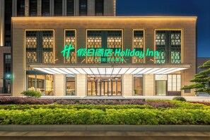 Hotel moderno com fachada imponente, amplas janelas e entrada coberta.