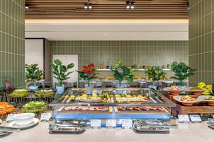 Un bufé con diversas opciones de comida, como carnes, ensaladas y frutas.