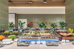 A buffet with various food items and a variety of plants.