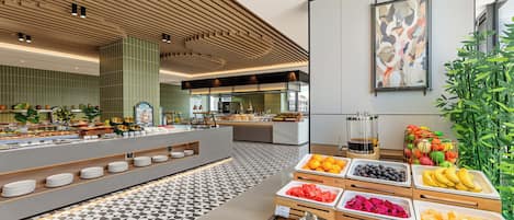 A buffet area with various food options, a coffee station, and a large abstract painting on the wall.