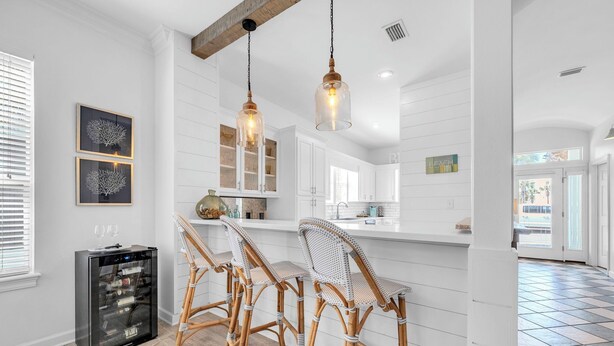 A kitchen with white cabinetry, a built-in island, and a wine cooler.