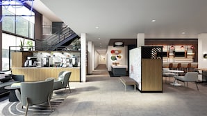 A modern hotel lobby with a reception desk, seating area, staircase, and dining space. - Atwell Suites Liberty - Kansas City East by IHG (Liberty)