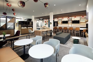Ein modernes Interieur mit Sitzbereichen, einer Bar und einer Küchenzeile.