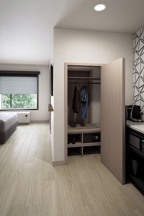 Ein modernes Schlafzimmer mit Bett, begehbarer Kleiderschrank und einem Fenster mit Jalousien.