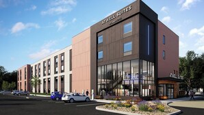 A modern building with 'ATWELL SUITES' signage, large windows, and a parking lot with cars. - Atwell Suites Liberty - Kansas City East by IHG (Liberty)