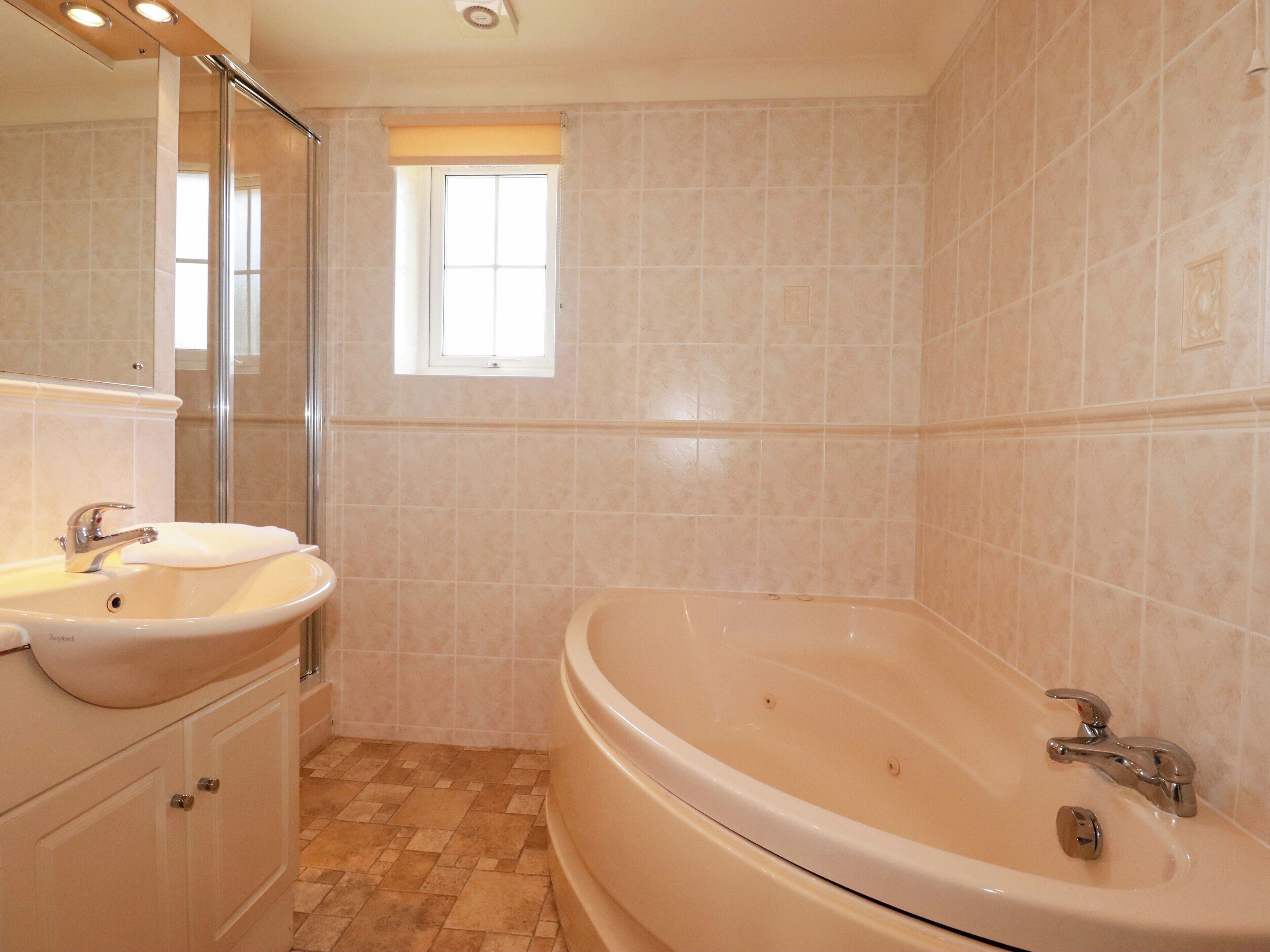 Un bagno con una vasca, un lavandino e una finestra.