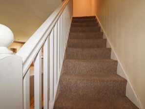 A carpeted staircase with white railings, leading to an upper floor. - 2 Atlantic Reach (St. Columb Major)