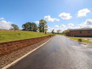 Eine gepflasterte Straße mit einer Backsteinmauer an einer Seite und einem Gebäude auf der anderen.