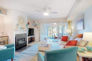 A living room with a fireplace, sofa, coffee table, and a television. - Mallard Lakes - 158 Cardinal Ln (Selbyville)