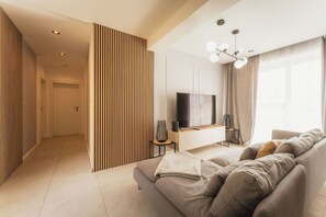 A modern living room with a sofa, TV, and decorative lighting. - Luxury Penthouse Jacuzzi, BBQ Terrace & Pool Table (Xagħra)