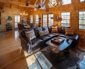 Ein gemütliches Cabin-Interieur mit Ledersofa, Holzböden und einem Essbereich.