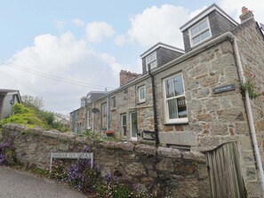 Un edificio de piedra con un letrero que dice 'KITTIWAKE' y 'HARBOUR VIEW TERRACE'.