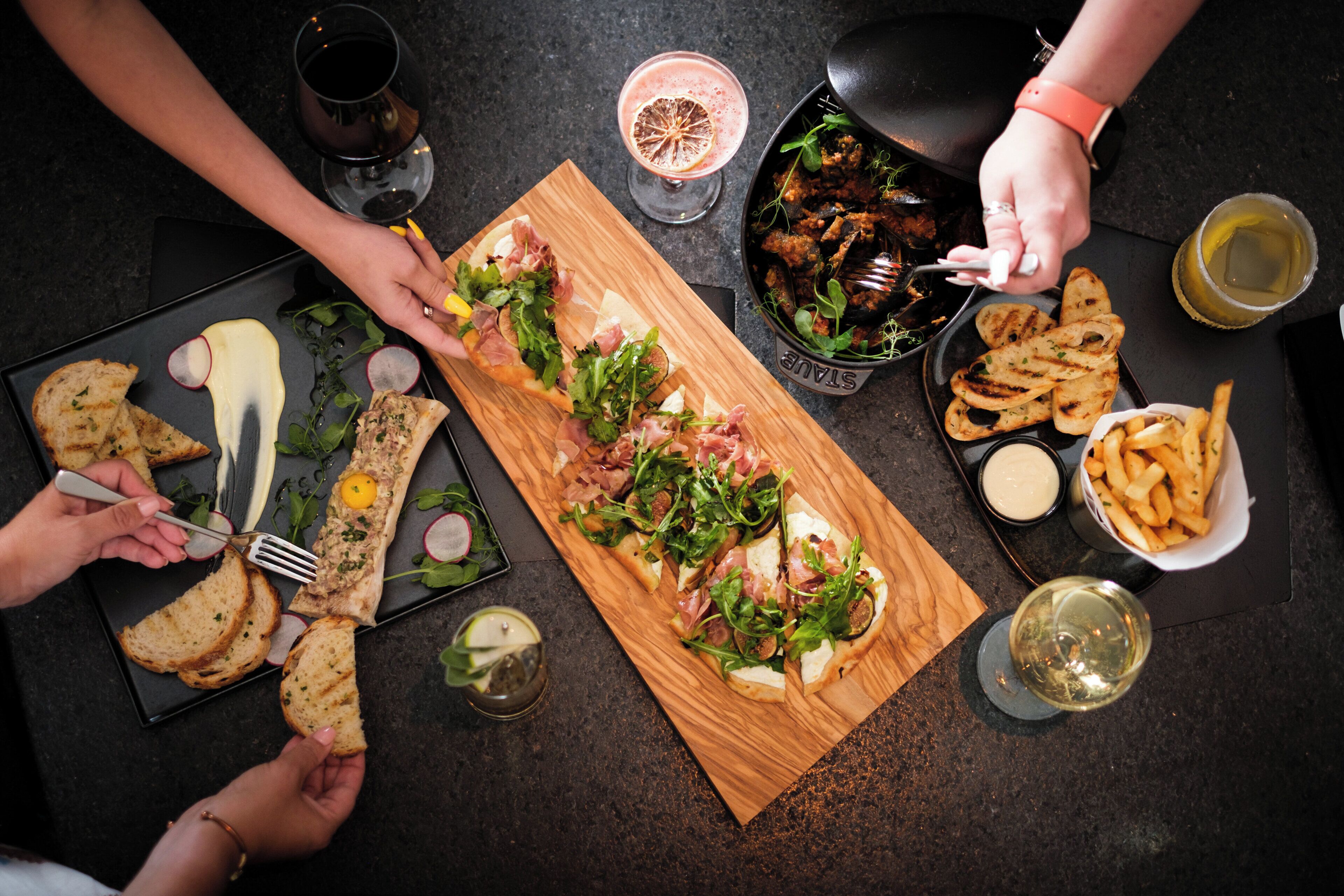 A dining table with various food items and drinks.