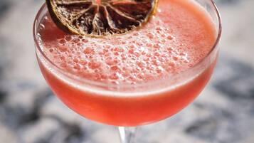A cocktail in a stemmed glass with a dried fruit garnish on top.